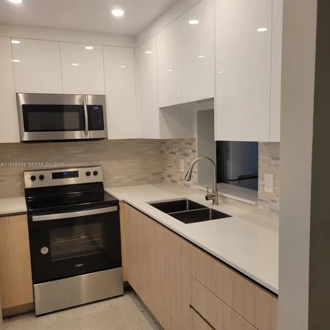 a kitchen with kitchen island a sink and stainless steel appliances