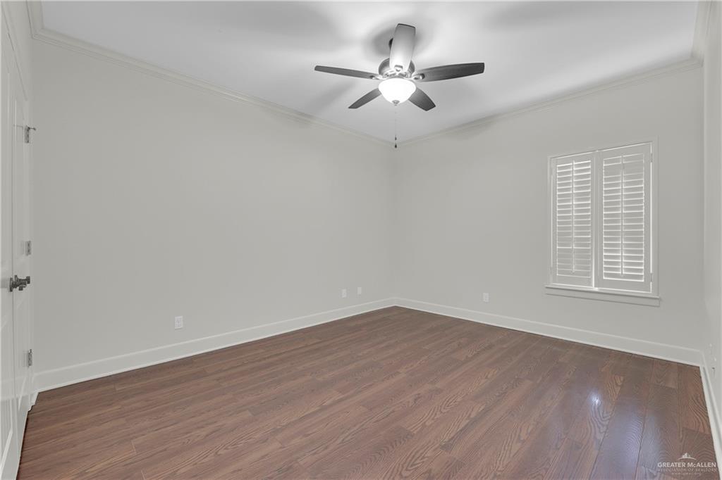 209 Robin Avenue McAllen, TX 78504 - Photo 14 of 20 an empty room with wooden floor ceiling fan and windows