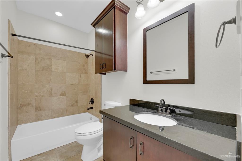 209 Robin Avenue McAllen, TX 78504 - Photo 16 of 20 a bathroom with a sink a toilet and shower a mirror