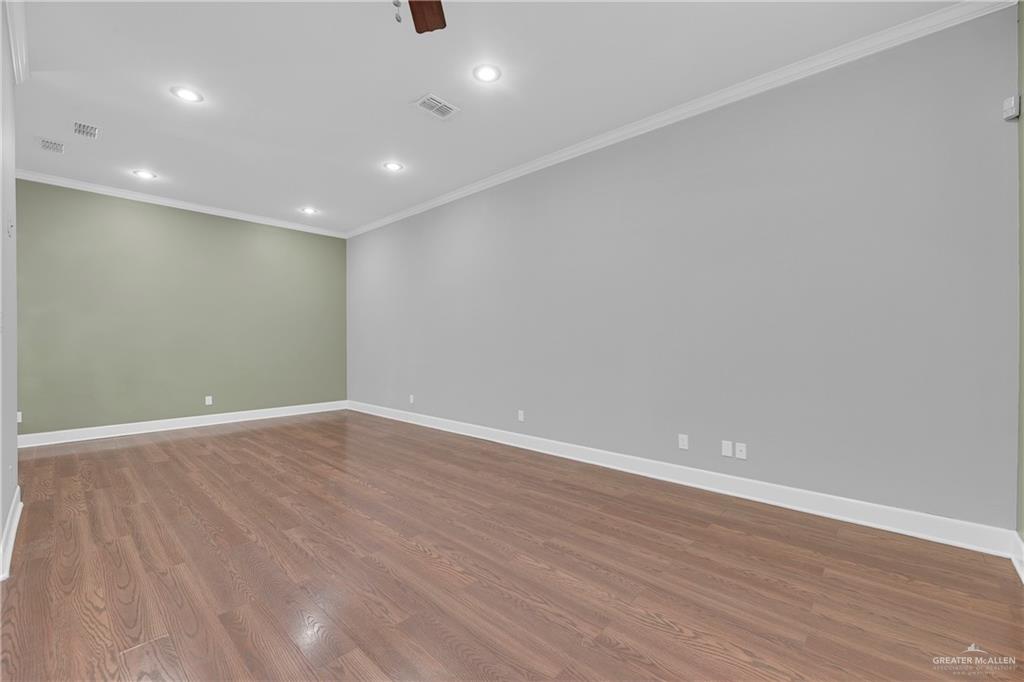 209 Robin Avenue McAllen, TX 78504 - Photo 5 of 20 an empty room with wooden floor and windows