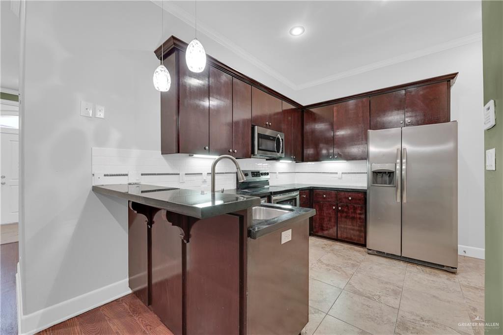209 Robin Avenue McAllen, TX 78504 - Photo 7 of 20 a kitchen with stainless steel appliances granite countertop a sink a stove and a refrigerator