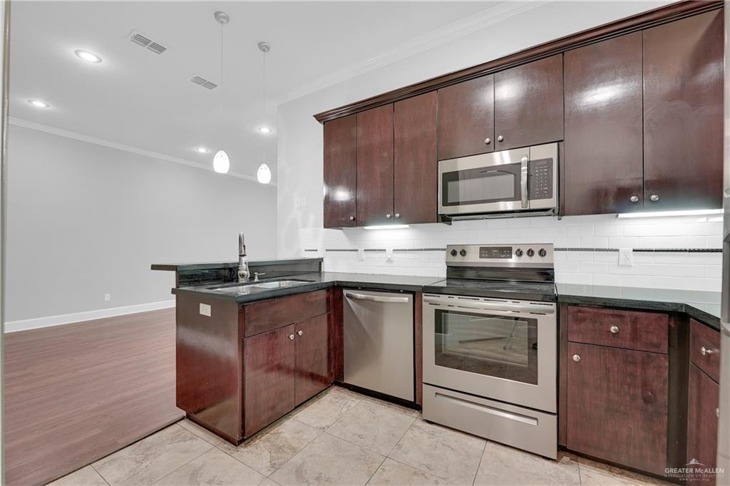 209 Robin Avenue McAllen, TX 78504 - Photo 8 of 20 a kitchen with sink a microwave and cabinets