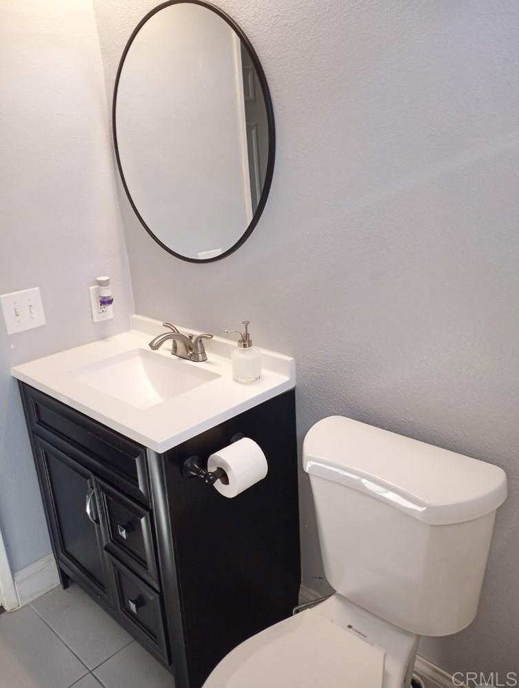 15935 Spring Oaks Road, Unit 63 El Cajon, CA 92021 - Photo 24 of 38 a bathroom with a toilet a sink and a mirror