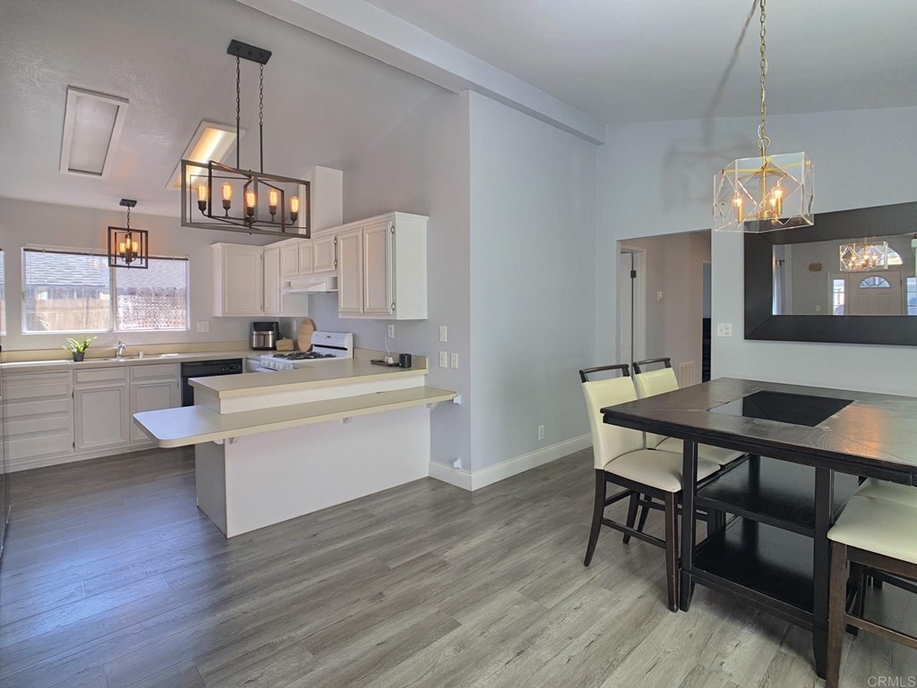 15935 Spring Oaks Road, Unit 63 El Cajon, CA 92021 - Photo 9 of 38 a kitchen with a dining table chairs and white cabinets