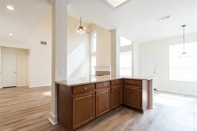 a large kitchen with stainless steel appliances a large counter top a sink and a window