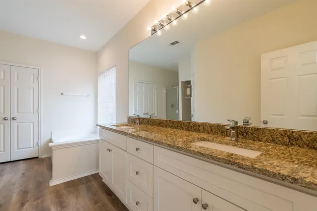 a bathroom with a granite countertop sink mirror and cabinets