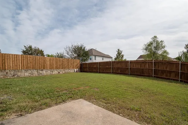 a view of a backyard with wooden fence