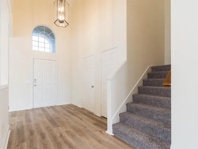 a view of a livingroom with wooden floor and staircase