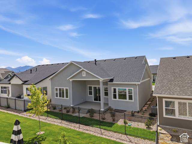 538 North Legend Circle, Unit 505 Mapleton, UT 84664 - Photo 4 of 48 Rear exterior featuring a covered patio, multiple windows, and a landscaped yard with a black metal fence