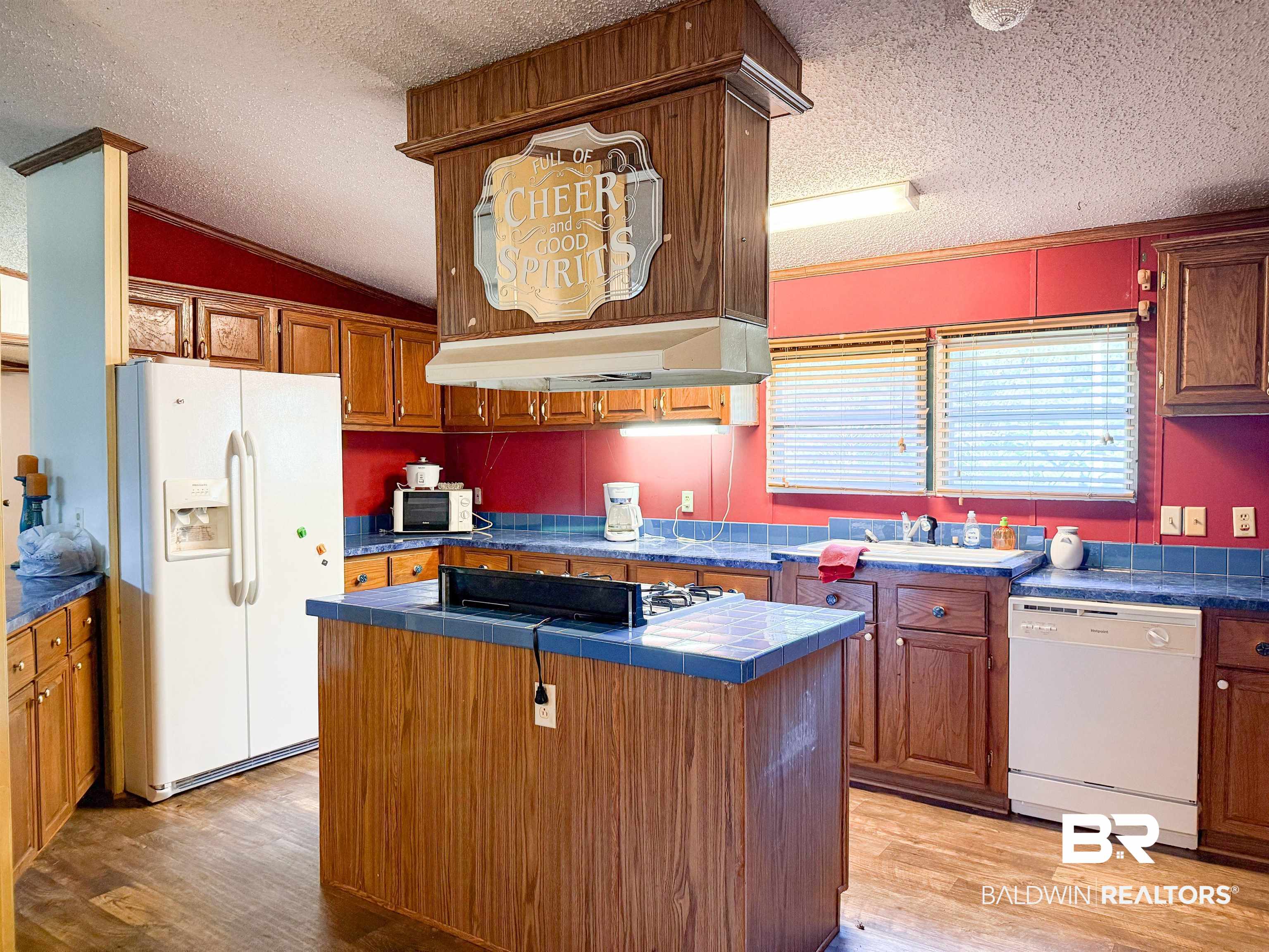 3346 Hoomesville Road Brewton, AL 36426 - Photo 8 of 16 Kitchen with white appliances, light wood finished floors, a textured ceiling, tile counters, and brown cabinets