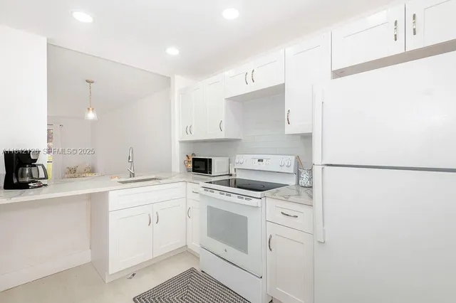 a kitchen with white cabinets and white appliances