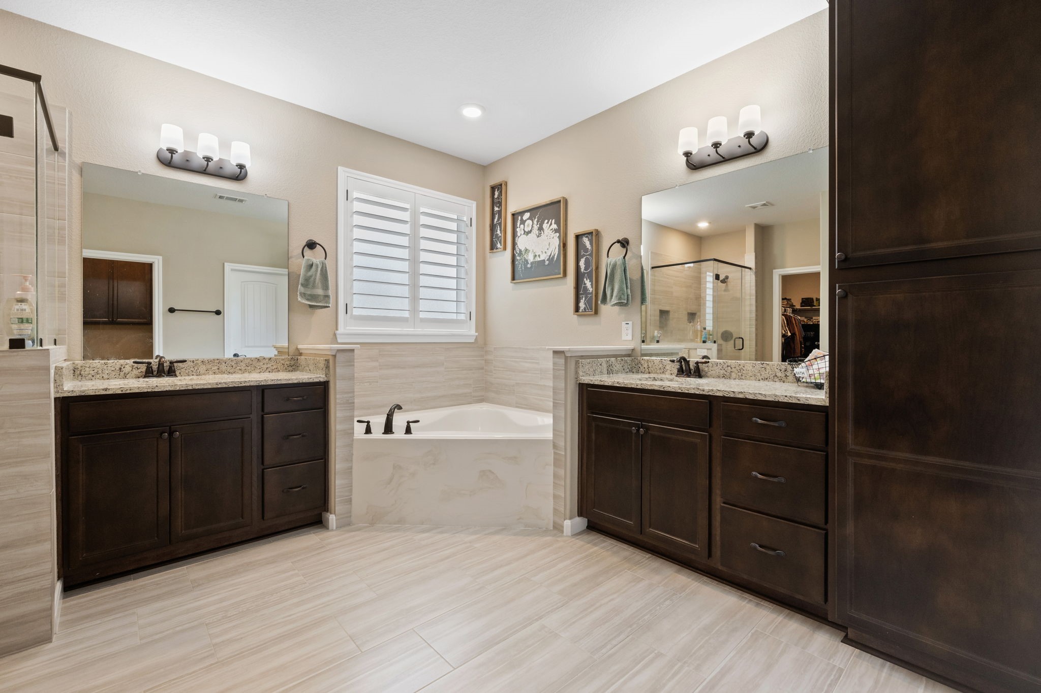 3004 Tyler Street Dayton, TX 77535 - Photo 19 of 34 a bathroom with a tub sink double vanity granite and a mirror