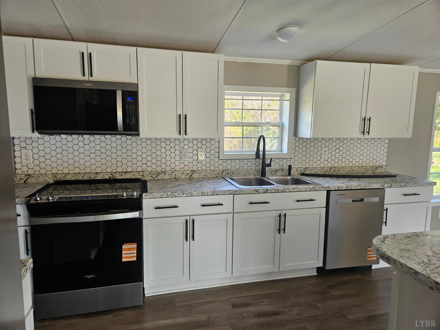 5629 Gladys Road Altavista, VA 24517 - Photo 4 of 29 a kitchen with granite countertop a sink stove and microwave