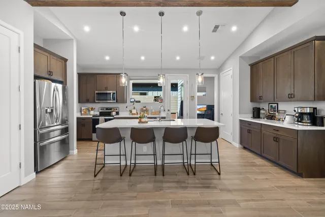 a kitchen with stainless steel appliances kitchen island granite countertop a refrigerator and a stove top oven