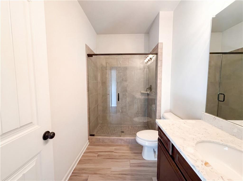 307 Valley View Trail Dallas, GA 30132 - Photo 29 of 41 a bathroom with a granite countertop sink a toilet a mirror and shower