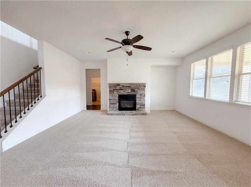 307 Valley View Trail Dallas, GA 30132 - Photo 5 of 41 a view of a livingroom with a fireplace a ceiling fan and windows
