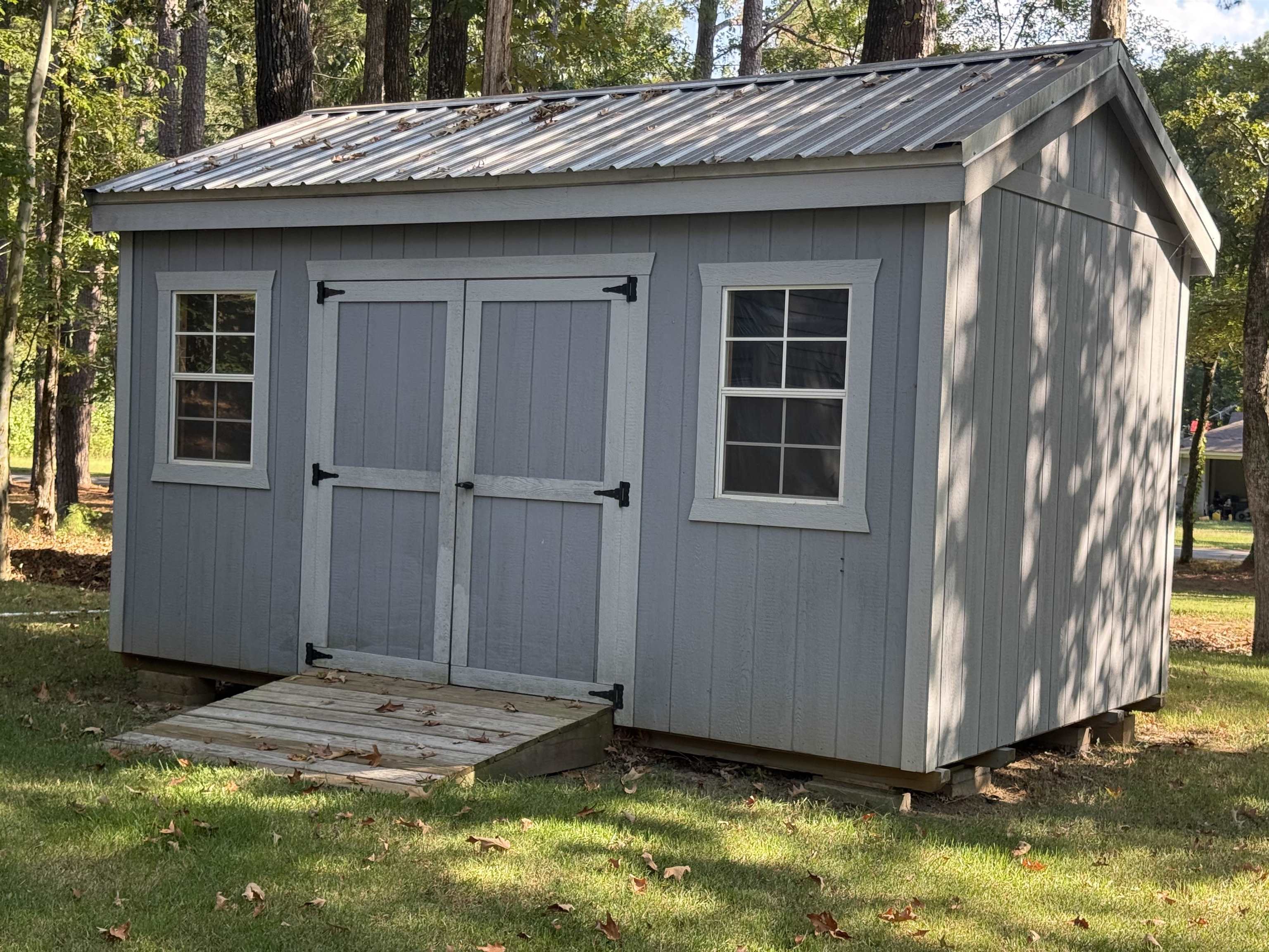185 Pine Tree Road Moscow, TN 38057 - Photo 29 of 36 Storage shed with a metal roof, double entry doors, two windows, and a wood ramp