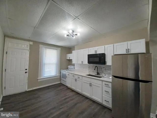 a kitchen with cabinets a sink and a refrigerator