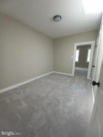 an empty room with windows and ceiling fan
