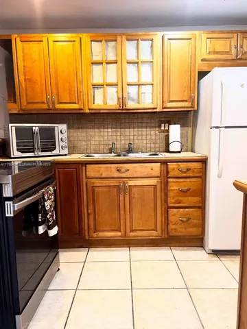 a kitchen with granite countertop a stove a sink and a microwave