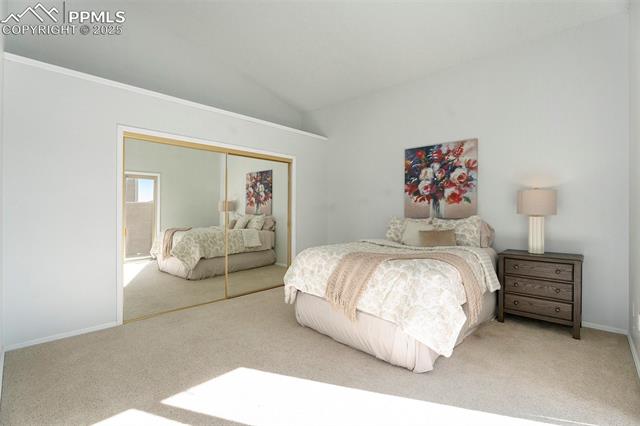 86 Rising Sun Terrace Colorado Springs, CO 80921 - Photo 10 of 36 Carpeted bedroom featuring vaulted ceiling and a closet