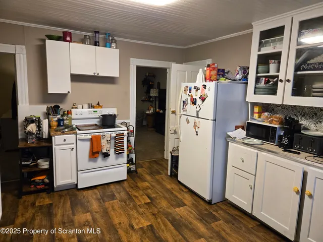 a kitchen with white cabinets and white appliances