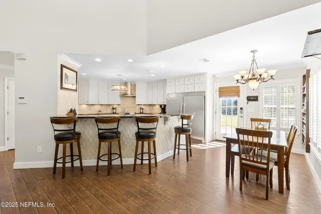 a kitchen with stainless steel appliances granite countertop a stove top oven a refrigerator a sink and dishwasher with white cabinets