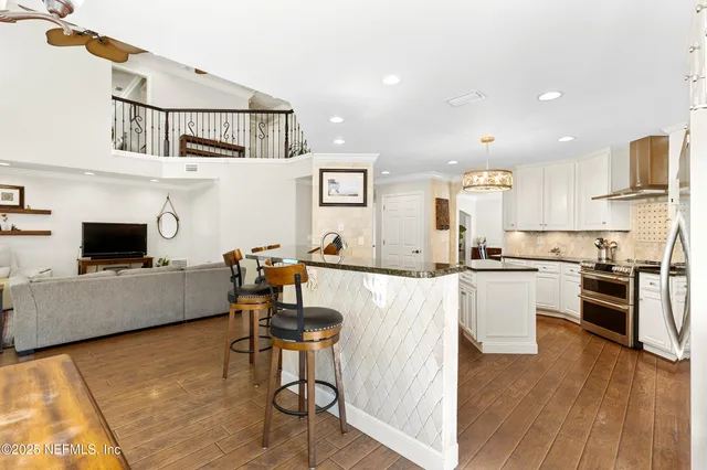 a kitchen with granite countertop a sink cabinets and stainless steel appliances