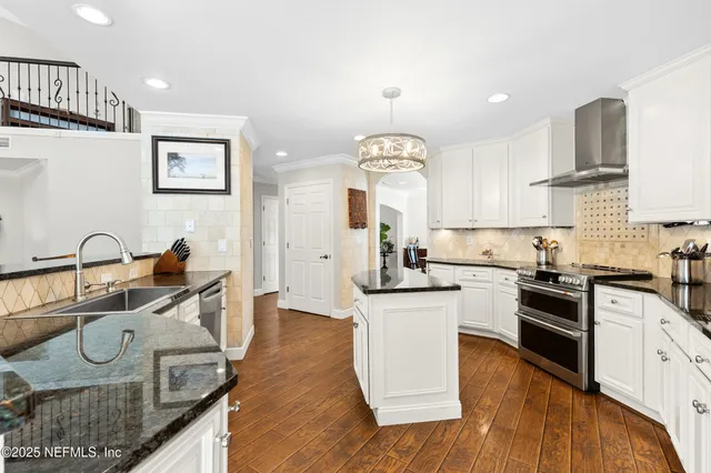 a kitchen with stainless steel appliances granite countertop a sink stove and cabinets