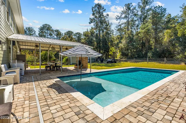 a view of a swimming pool with a patio and yard