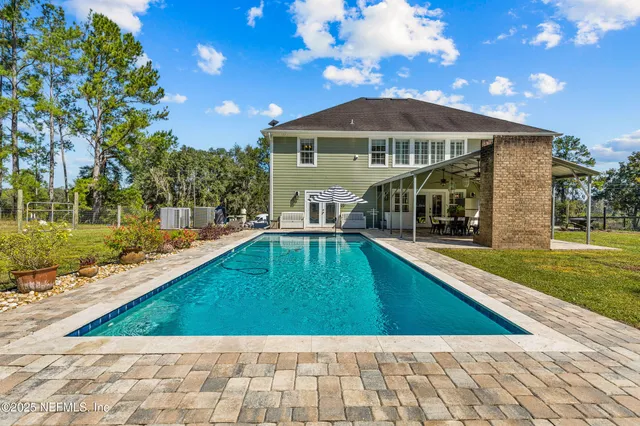 a view of a house with backyard and sitting area