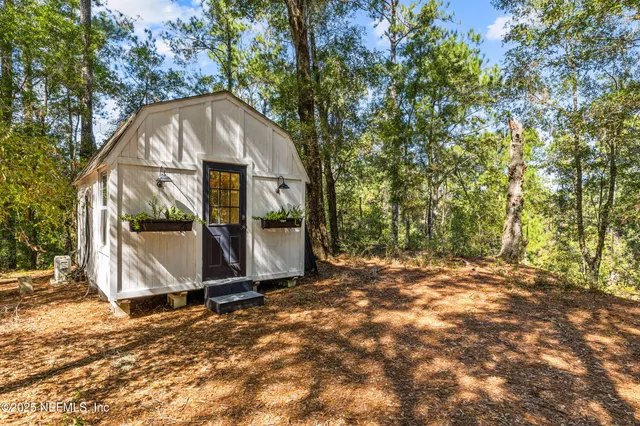 an aerial view of residential houses with outdoor space and trees