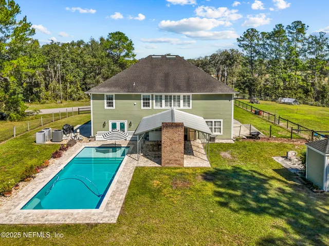 an aerial view of a swimming pool with yard