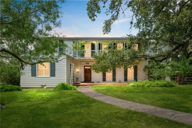 a front view of a house with a yard and trees