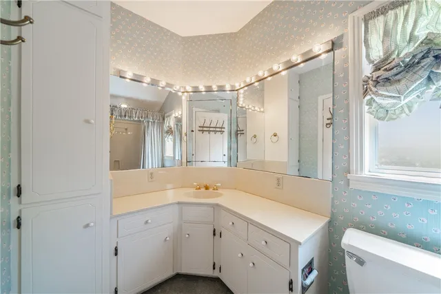 a spacious bathroom with a double vanity sink mirror and toilet