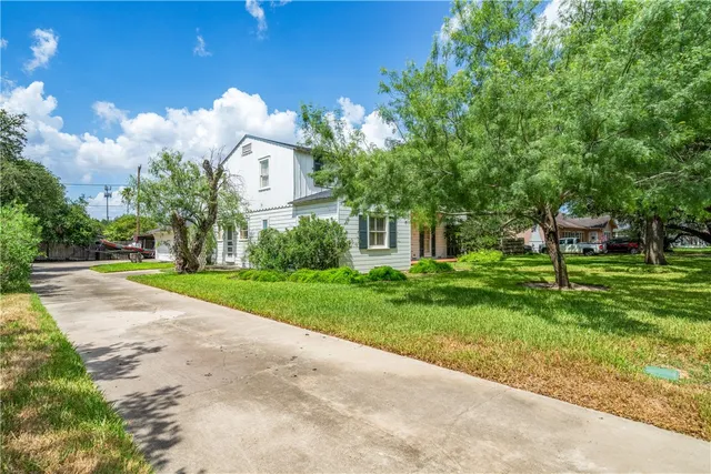 a view of a house with a yard and a street