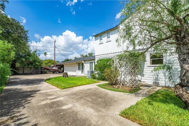 a view of a house with a yard and pathway