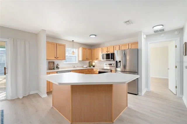a large kitchen with kitchen island a sink stainless steel appliances and cabinets