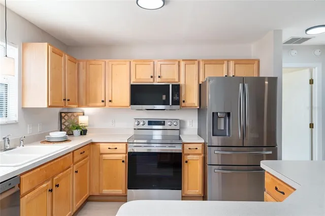 a kitchen with stainless steel appliances granite countertop a refrigerator stove and sink