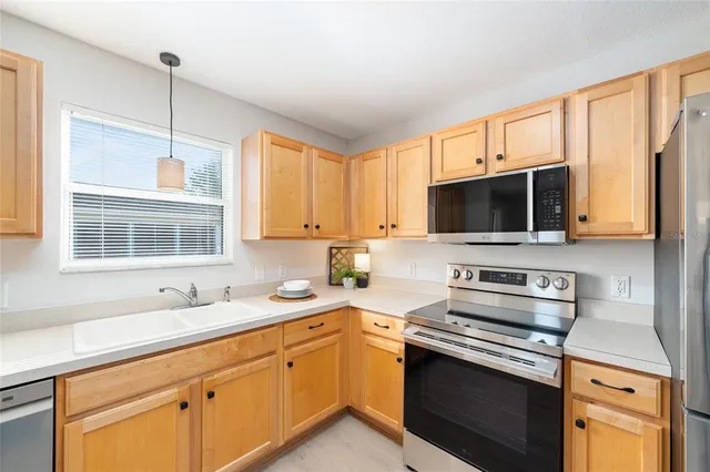 a kitchen with stainless steel appliances a stove microwave and sink