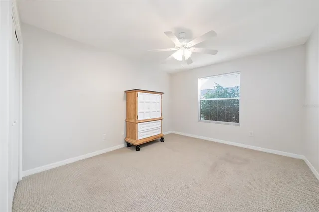 an empty room with windows and fan