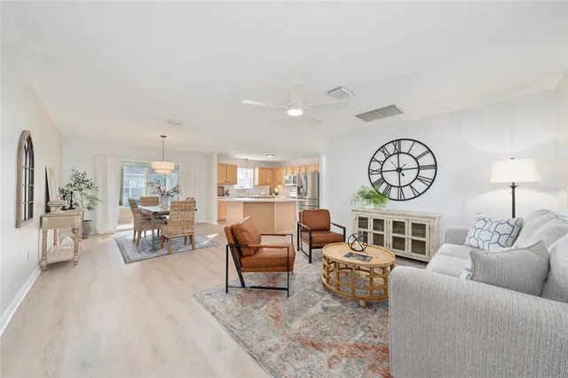 a living room with furniture a clock and a large window