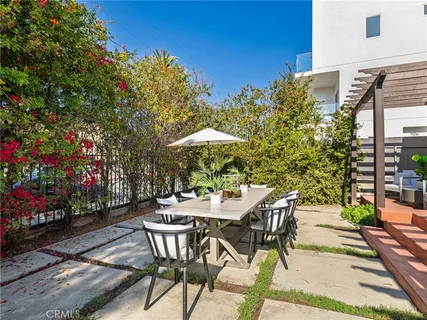 a view of a patio with couches table and chairs and potted plants