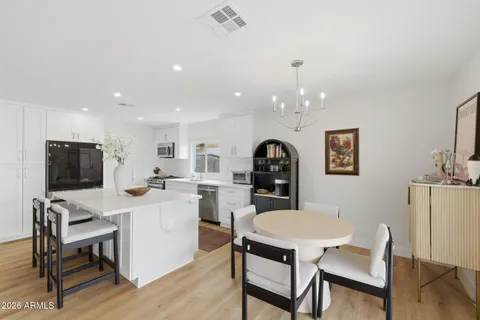 a living room with furniture a dining table and a chandelier