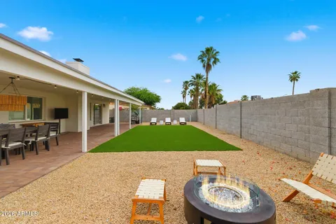 a patio with a table and chairs and a barbeque