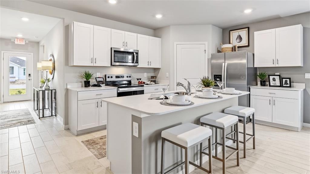 17752 Shade Tree Loop Punta Gorda, FL 33982 - Photo 5 of 40 a kitchen with stainless steel appliances kitchen island granite countertop a sink and cabinets