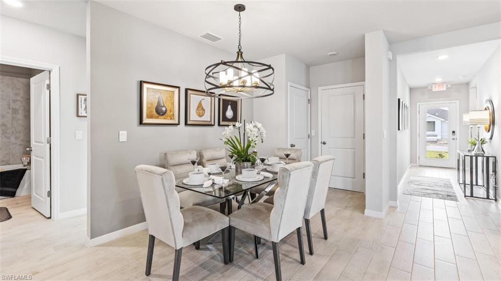 17752 Shade Tree Loop Punta Gorda, FL 33982 - Photo 6 of 40 a dining room with furniture a chandelier and wooden floor