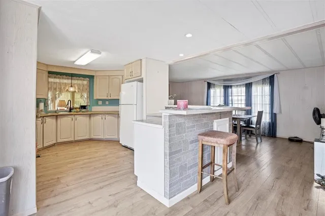 a kitchen with stainless steel appliances kitchen island granite countertop a refrigerator and a stove top oven