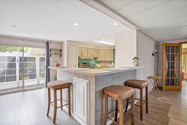 a kitchen with granite countertop white cabinets and chairs