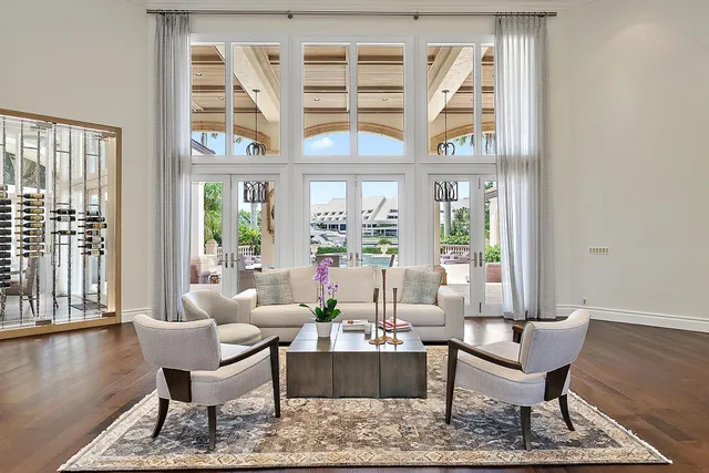 a living room with furniture floor to ceiling window and wooden floor